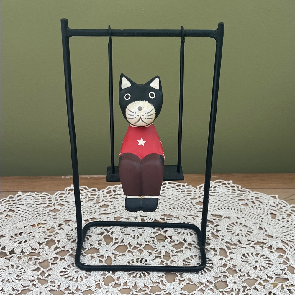 Hand carved cat on a swing